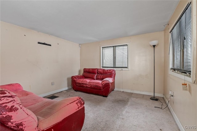 living area featuring baseboards and light colored carpet