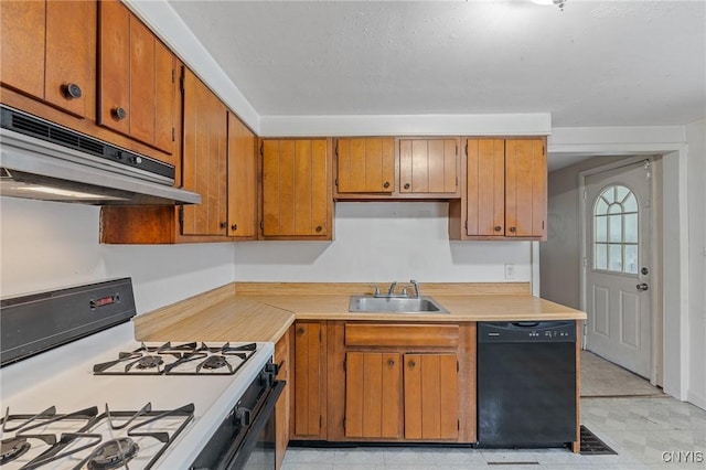 kitchen featuring gas range gas stove, light countertops, a sink, dishwasher, and under cabinet range hood