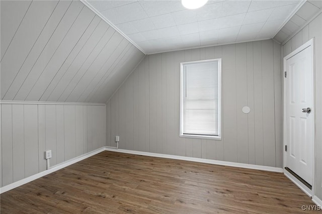 additional living space featuring lofted ceiling, dark wood-type flooring, and baseboards