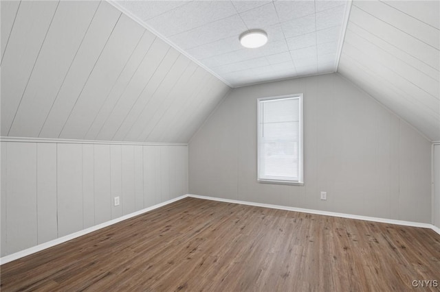 bonus room featuring baseboards, vaulted ceiling, and wood finished floors