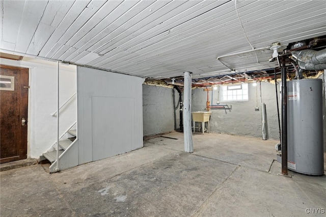 basement featuring gas water heater and a sink