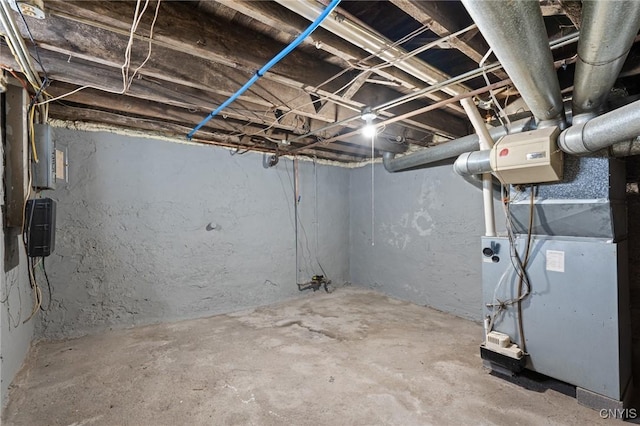 unfinished basement with electric panel and heating unit