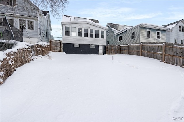 snow covered house with fence