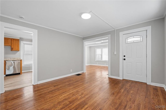 foyer entrance with baseboards, ornamental molding, and wood finished floors