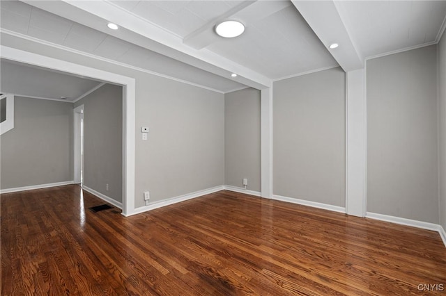 unfurnished room with baseboards, dark wood finished floors, visible vents, and crown molding