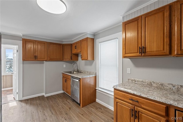 kitchen featuring brown cabinets, a sink, light wood-style flooring, and dishwasher