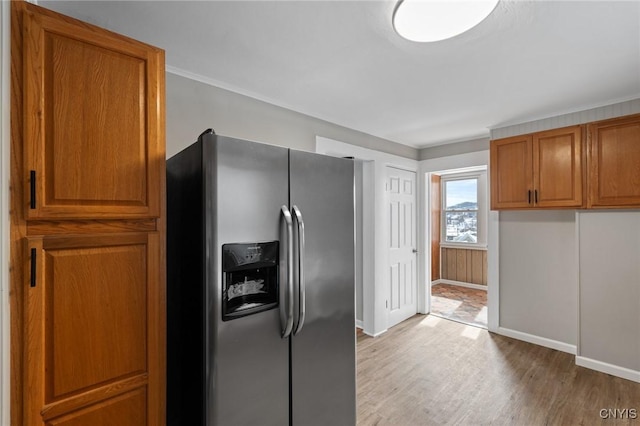 kitchen featuring baseboards, brown cabinets, stainless steel refrigerator with ice dispenser, and light wood finished floors