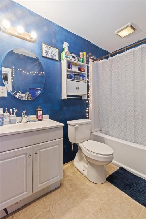 bathroom with vanity, tile patterned floors, toilet, and shower / bathtub combination with curtain