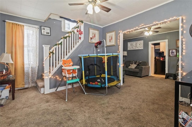 recreation room with carpet, crown molding, and ceiling fan