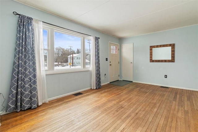 foyer featuring light wood-type flooring, visible vents, and baseboards