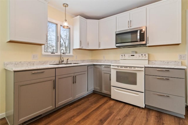 kitchen featuring stainless steel microwave, a sink, white cabinetry, hanging light fixtures, and white range with electric cooktop