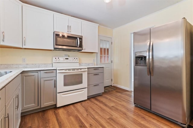 kitchen with appliances with stainless steel finishes, light countertops, gray cabinetry, and white cabinetry