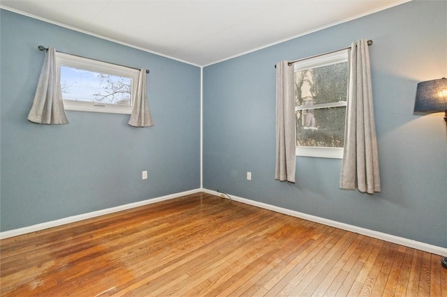 unfurnished room with crown molding, baseboards, and hardwood / wood-style flooring