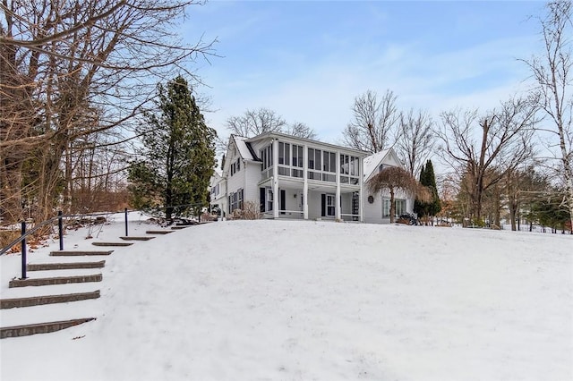 snow covered house with a sunroom