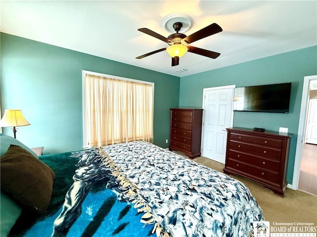 bedroom with carpet flooring, ceiling fan, and visible vents