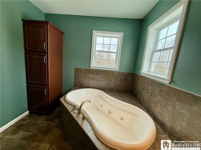 bathroom with baseboards and a whirlpool tub