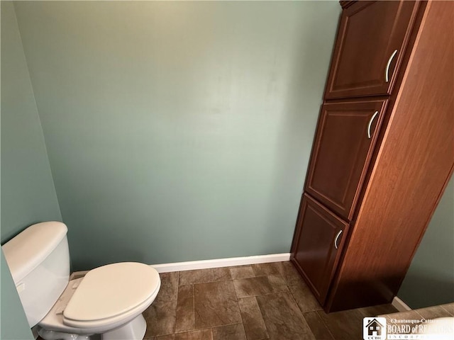 bathroom featuring baseboards and toilet