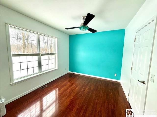 unfurnished bedroom with a ceiling fan, wood finished floors, visible vents, and baseboards