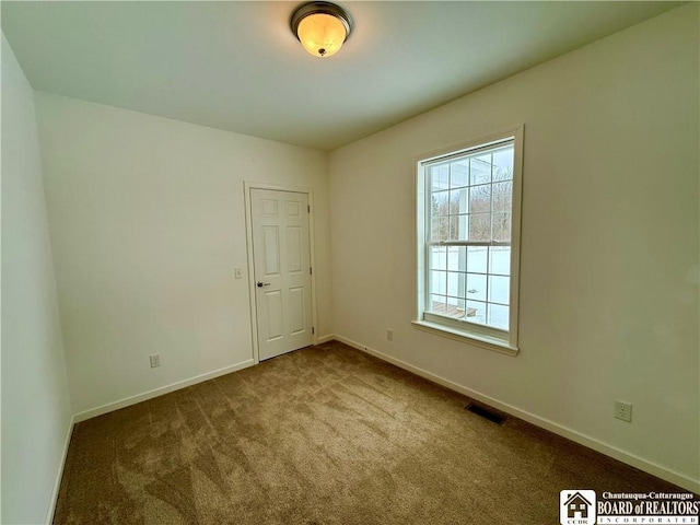 carpeted empty room featuring visible vents and baseboards