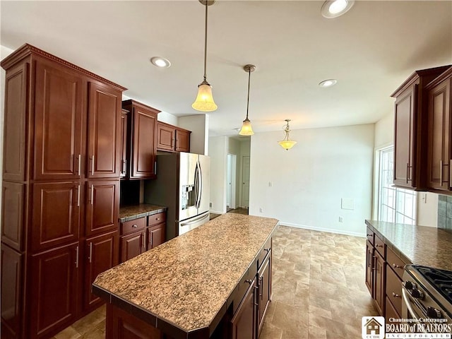 kitchen featuring baseboards, a kitchen island, recessed lighting, stainless steel appliances, and pendant lighting