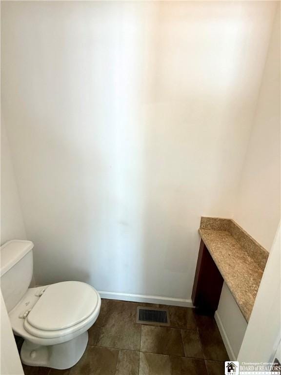 bathroom featuring visible vents, toilet, and baseboards