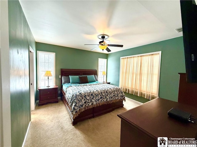 carpeted bedroom with visible vents, baseboards, and a ceiling fan