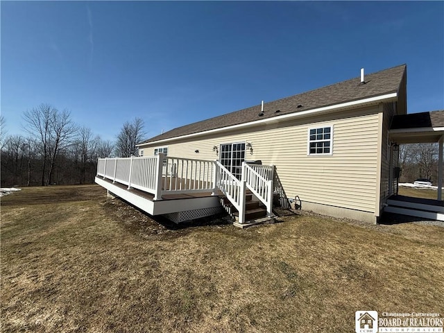 rear view of house with a lawn and a wooden deck