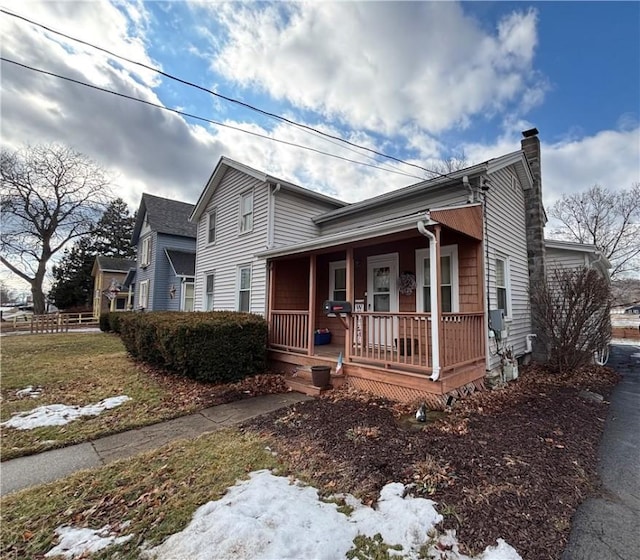 view of front of house featuring covered porch and a chimney