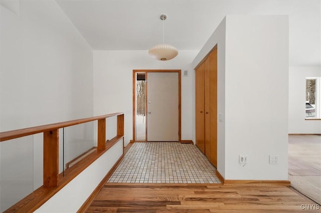 hall with baseboards and light wood-style floors