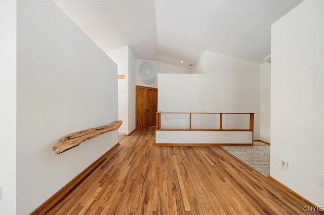 empty room featuring lofted ceiling and light wood-type flooring