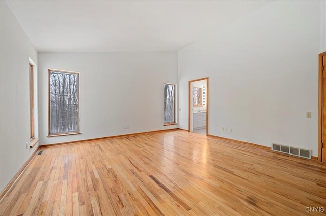 unfurnished room featuring light wood finished floors, baseboards, and visible vents