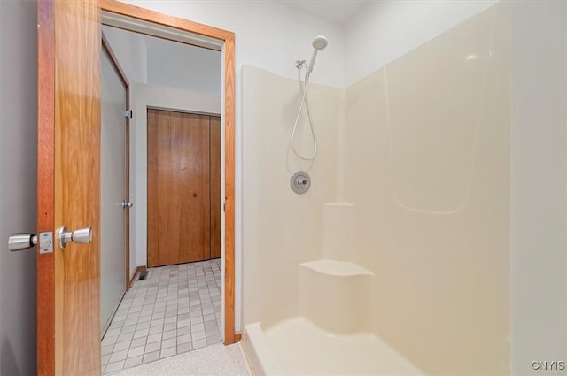 bathroom with a shower stall and tile patterned floors