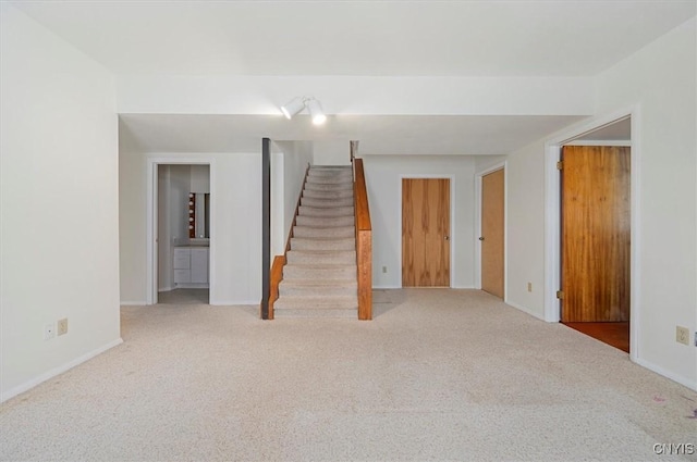 interior space with carpet flooring, stairway, and baseboards