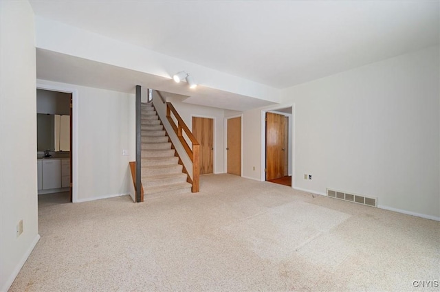 unfurnished room with stairs, carpet flooring, visible vents, and baseboards