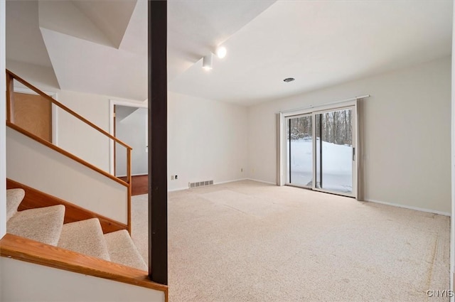 basement with carpet floors, baseboards, stairs, and visible vents