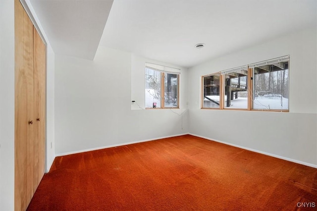 carpeted empty room with baseboards