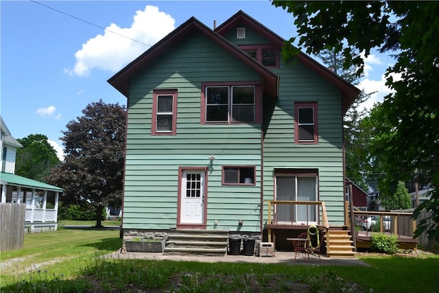 back of property featuring a deck and a yard