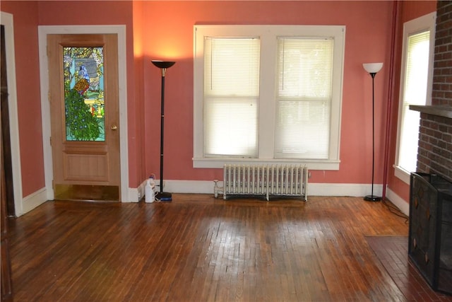 interior space with radiator, baseboards, and hardwood / wood-style floors