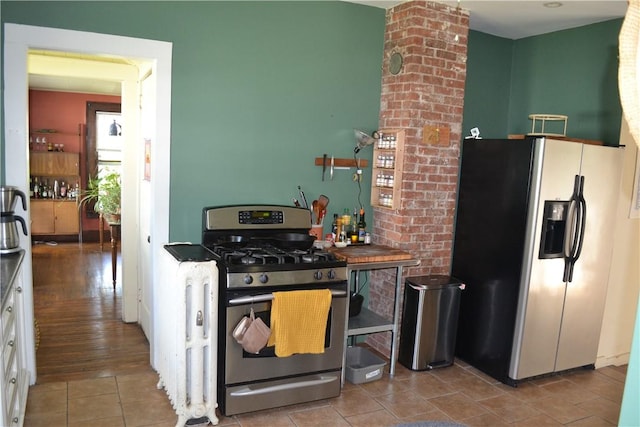 kitchen featuring stainless steel appliances, tile patterned floors, and white cabinets