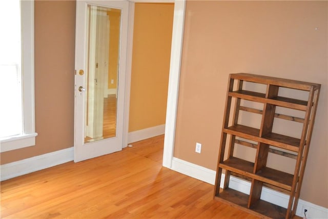 unfurnished room with light wood-style flooring and baseboards