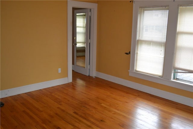 unfurnished room with baseboards and wood finished floors