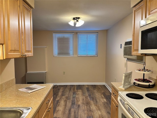 kitchen with baseboards, stainless steel microwave, light countertops, and dark wood finished floors