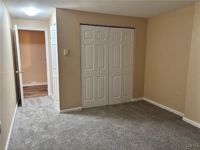 unfurnished bedroom featuring light carpet, baseboards, and a closet