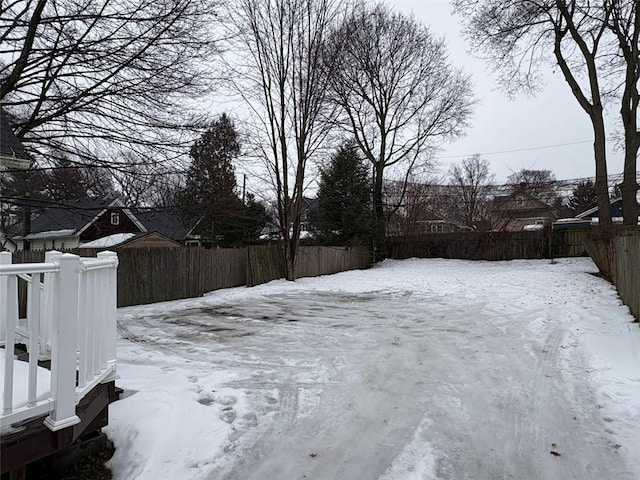 yard covered in snow featuring fence