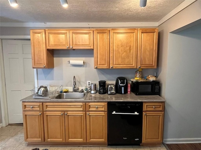 kitchen featuring black microwave, a textured ceiling, a sink, baseboards, and brown cabinets