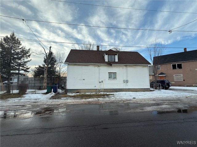 snow covered garage featuring fence