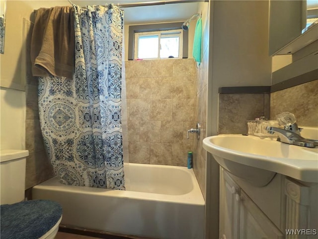 full bath with toilet, shower / bath combo with shower curtain, and vanity