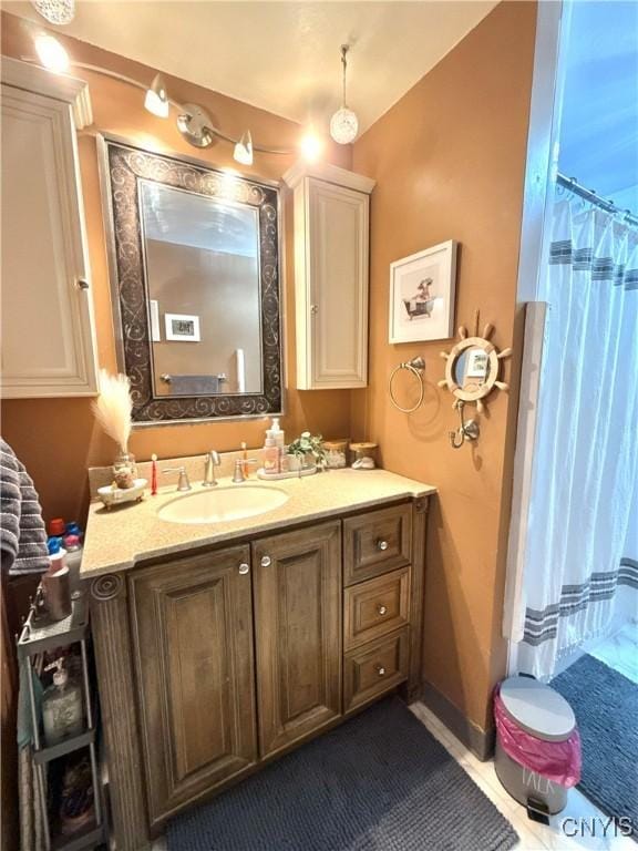 full bathroom with a shower with shower curtain, tile patterned floors, baseboards, and vanity