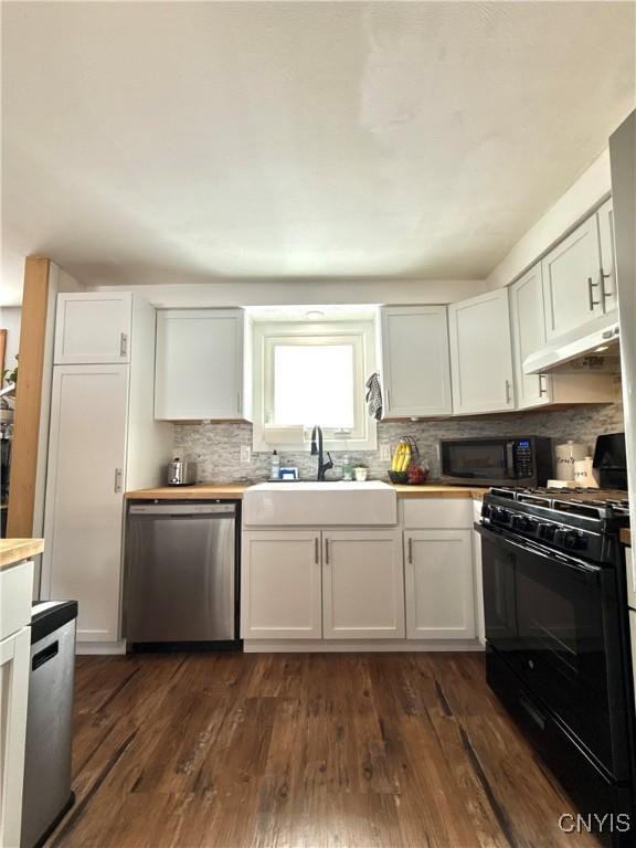 kitchen with gas stove, white cabinetry, a sink, dishwasher, and under cabinet range hood