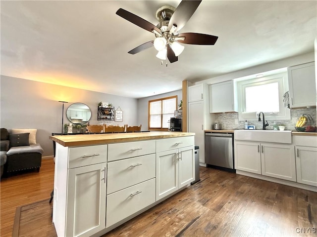 kitchen featuring a sink, wood counters, white cabinetry, and stainless steel dishwasher